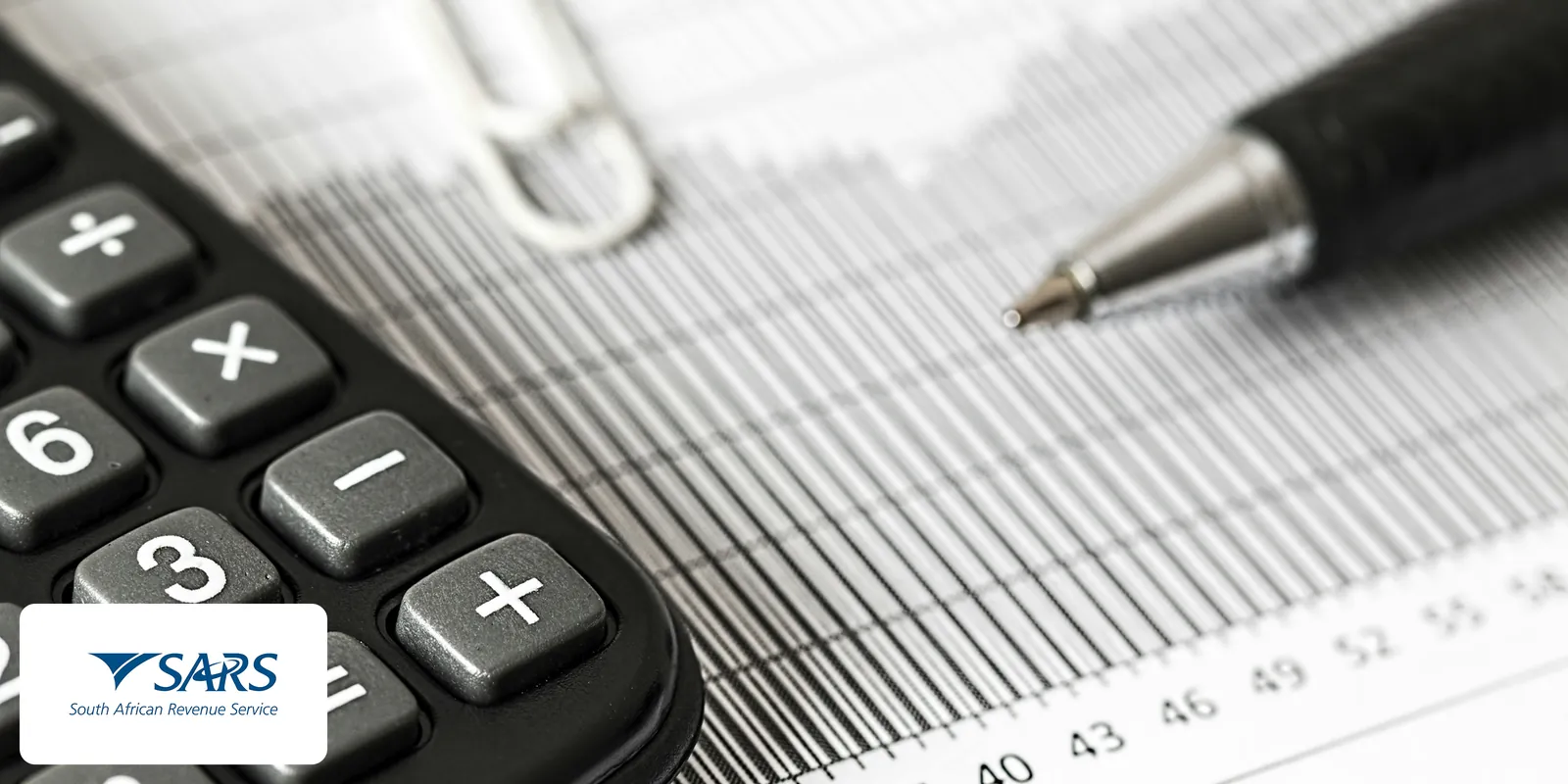 SARS (South African Revenue Service) logo over a close-up of a calculator and pen on a printed chart